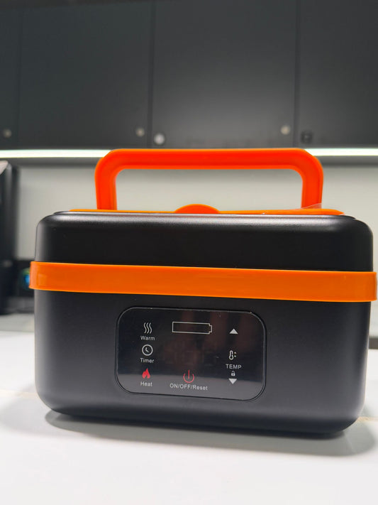 Black and orange portable heater on a white surface with a blurred background